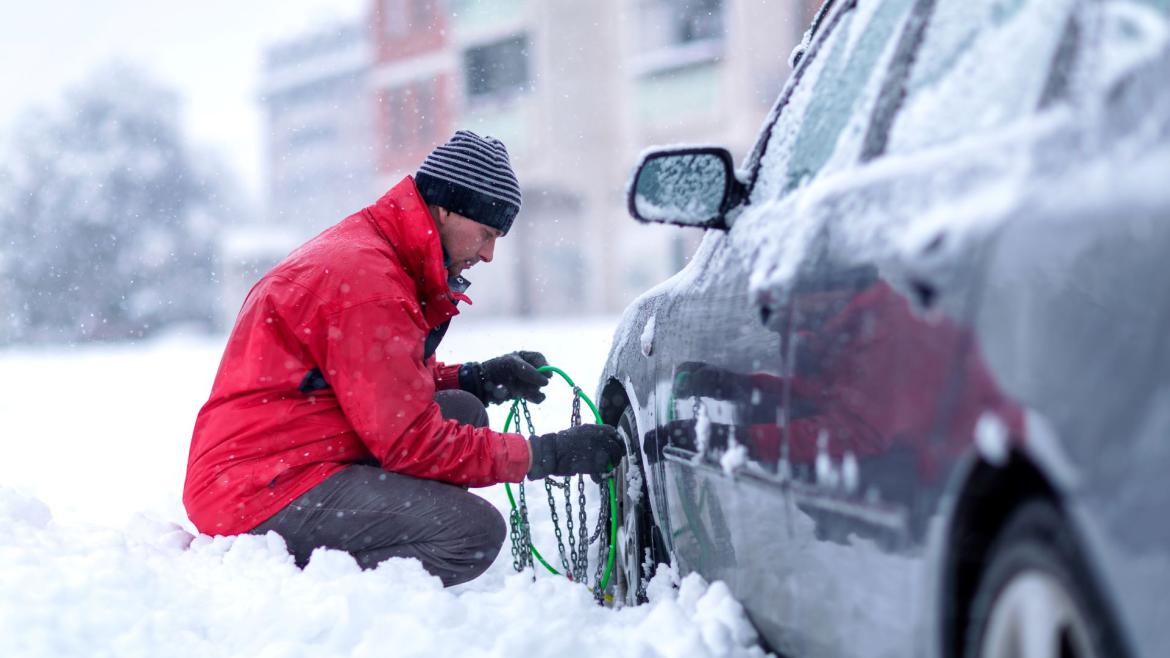 Uomo monta catene da neve